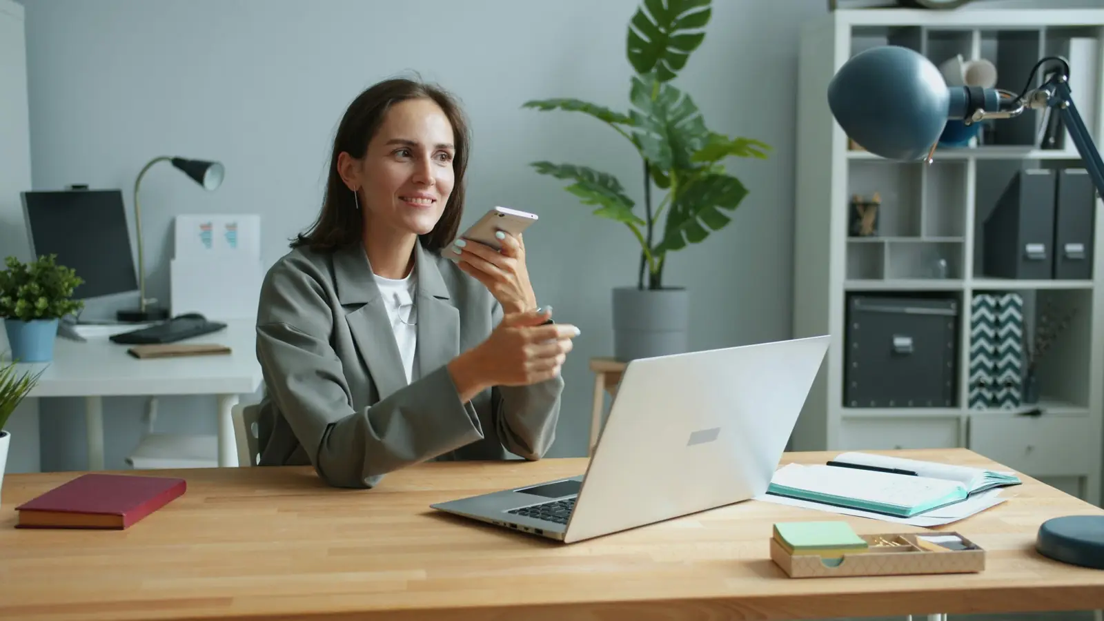 Une femme souriante au téléphone à son bureau