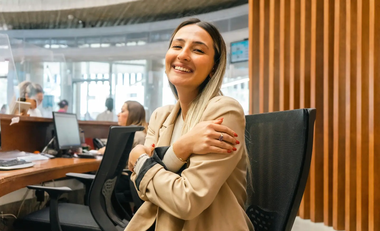 Une femme souriante, bras croisés sur les épaules, soulagée