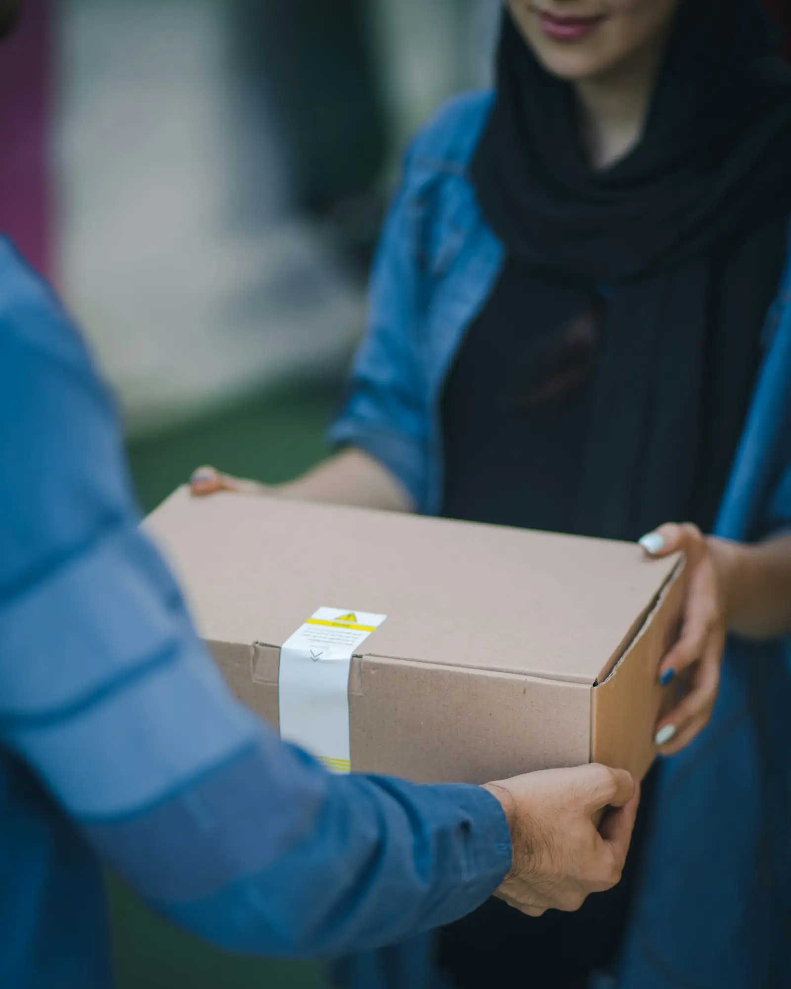 Une personne tend un colis en carton