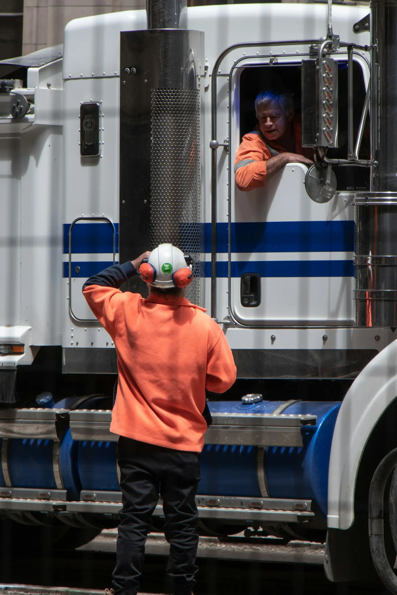 Un homme debout devant un camion de marchandises